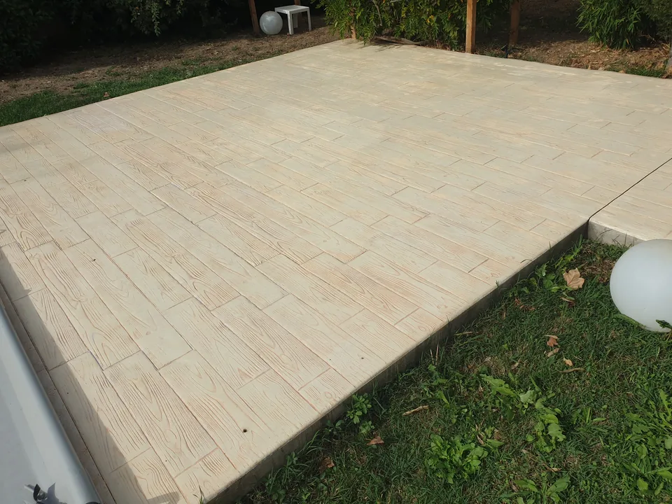 Terrasse en béton imprimé clair avec un motif de lames de bois.